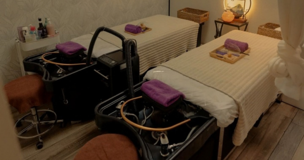 Two head spa treatment beds with scalp washing stations and purple towels in a relaxing spa room.